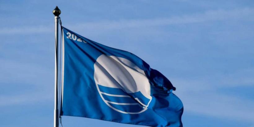 Waving blue flag, symbolizing clean waters and serene skies.